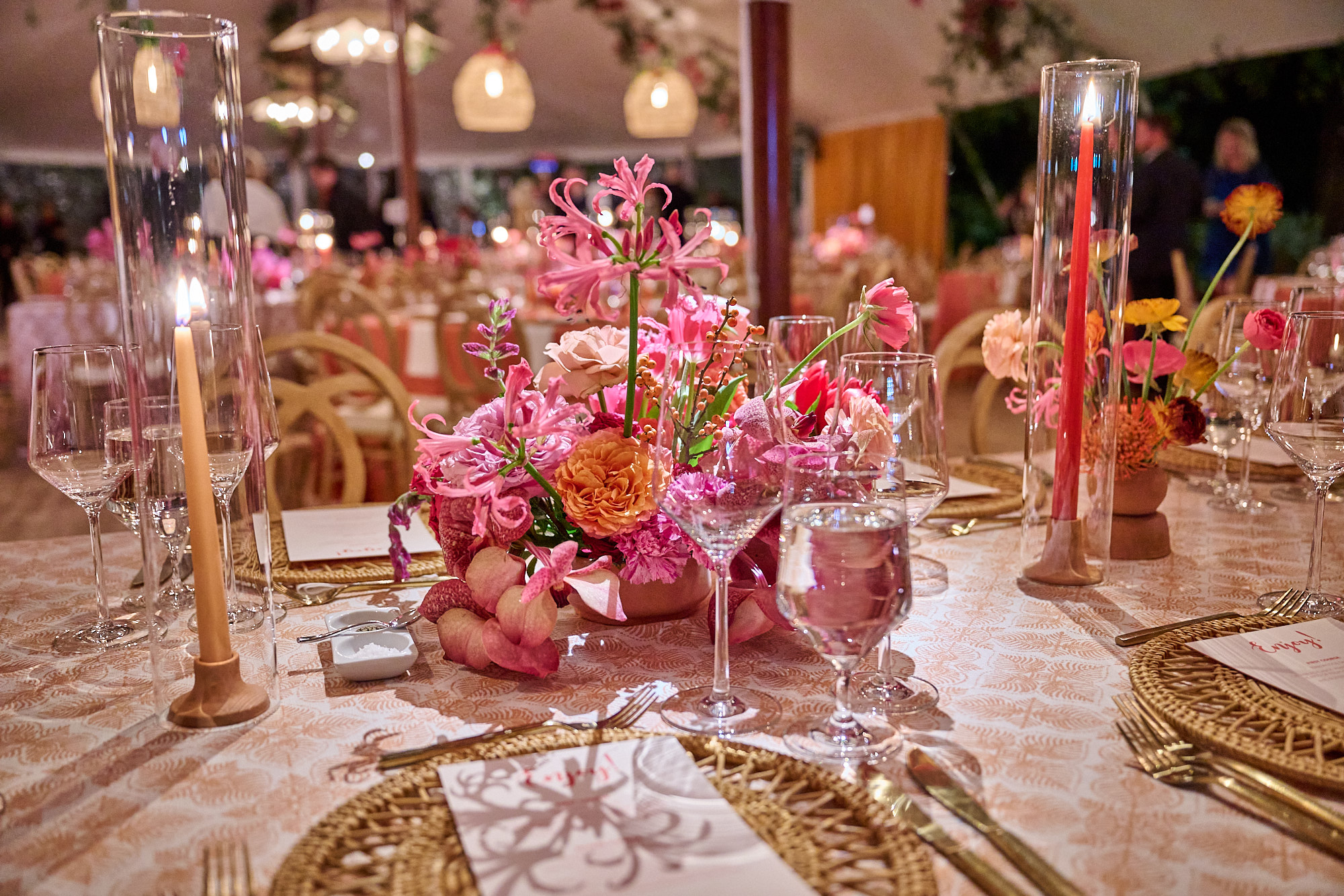 Table setting with flowers, glassware, and candle in decorative arrangement
